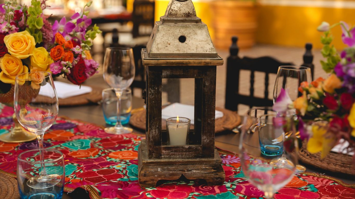Table Decor with colorful Mexican-artisan table runner, flowers and lantern with lit candle